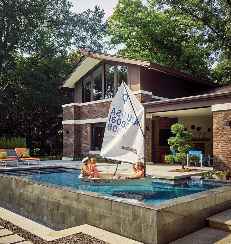 Wade and Hodges Miller have fun sitting in a mini sailboat floating in the pool outside their Myers Park home in Charlotte.