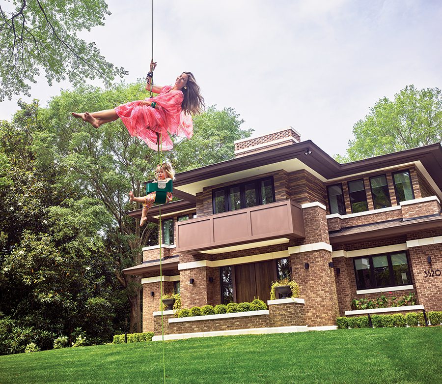 Hodges Miller and daughter, Mia, rappel in style outside their Selwyn Avenue home in Charlotte. Hodges wears a vintage dress from Raleigh-based House of Landor.