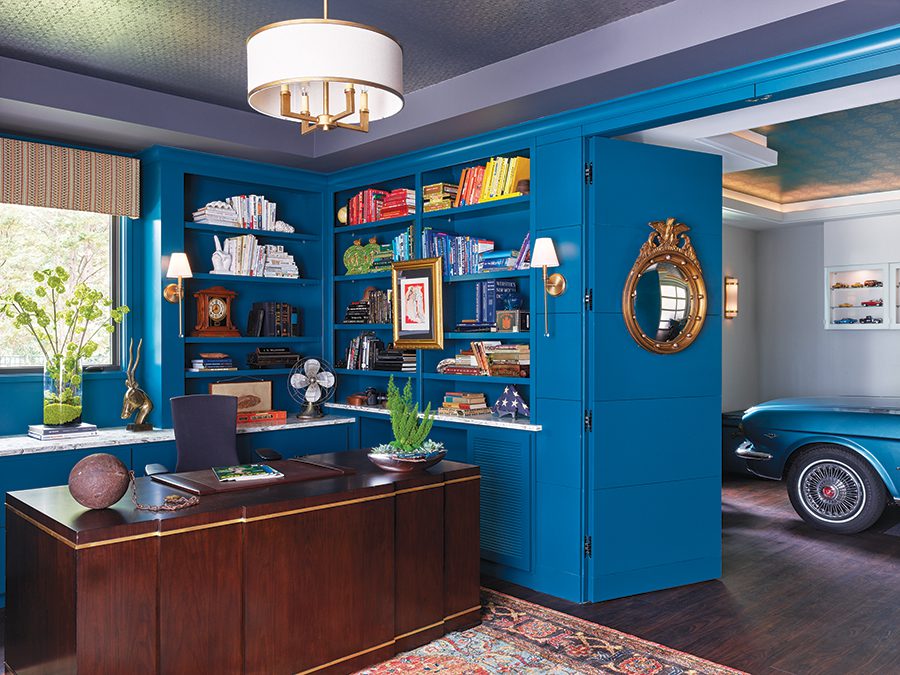 Bright blue walls and a dark wood desk make a for stunning home office inside the home of Wade and Hodges Miller.