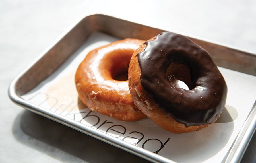 A chocolate covered doughnut resting on a glazed doughnut from milkbread in Davidson, NC.