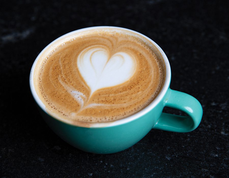 A cappuccino with a heart on top in a teal coffee cup from Summitt Coffee in Davidson, NC.