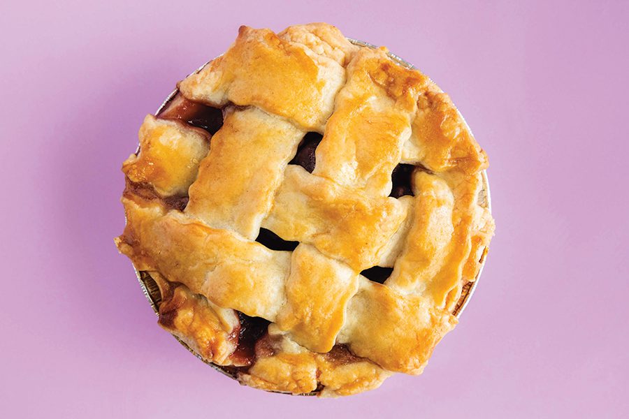 A pie sits on top of a purple background