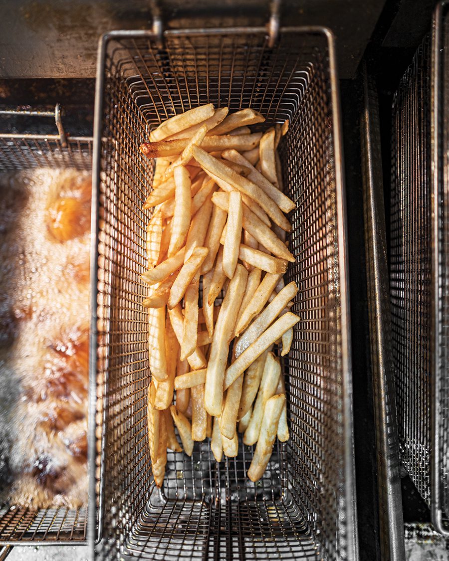 A stack of fries getting ready to be submerged in a deep frier