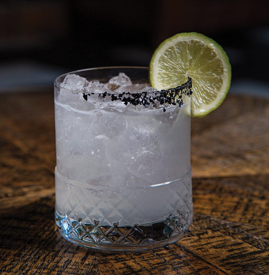 A small cocktail glass with a lime garnish