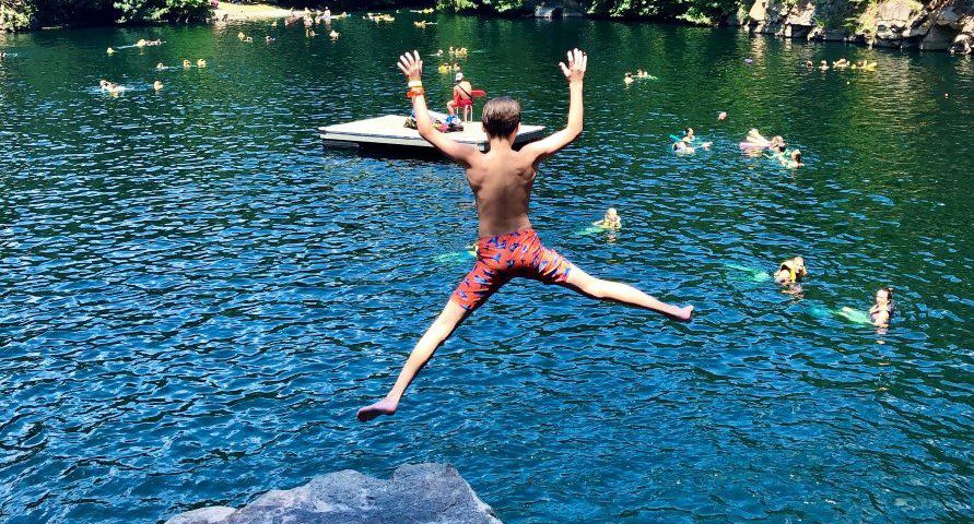Boy jumping into the water at Carrigan Farms Quarry.