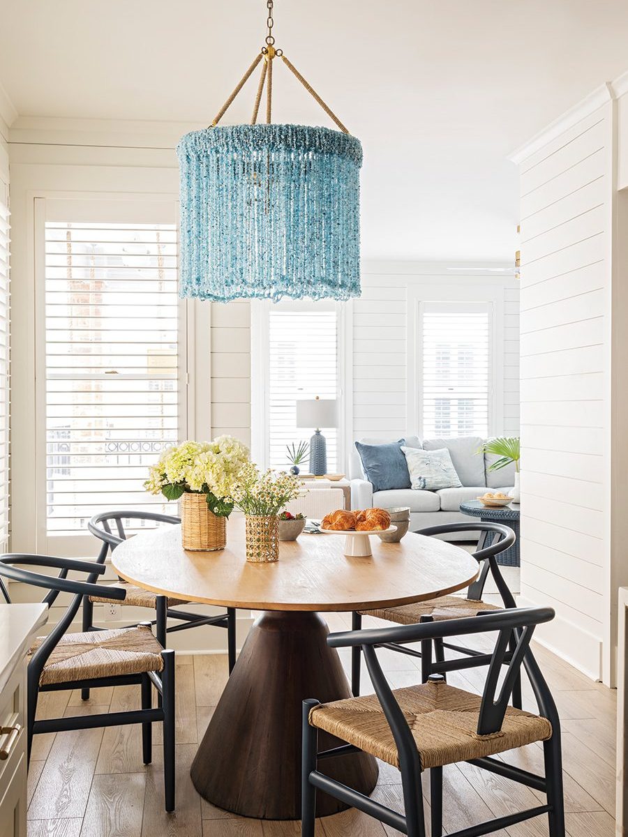 A breakfast room with a blue beaded chandelier at a vacation home in Wild Dunes designed by Traci Zeller Interiors. 