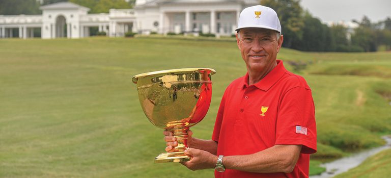Davis Love III holding the Presidents Cup in front of Quail Hollow Club