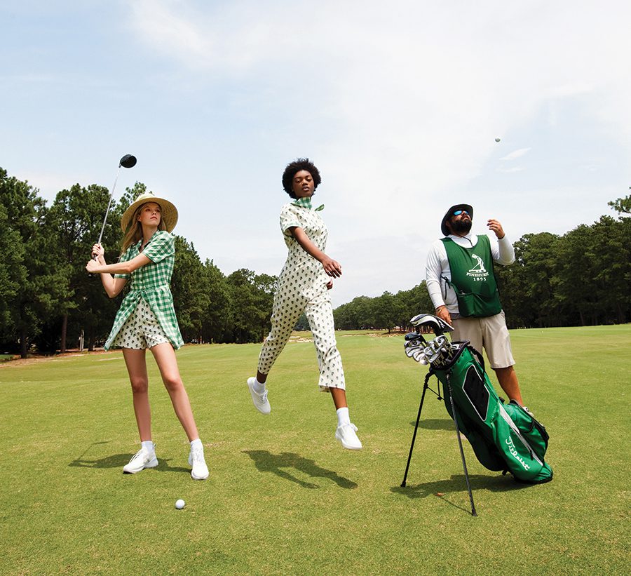 Models Elaine Metcalf and Carmen York at Pinehurst No. 2 golf course with caddy Russell Bauer.