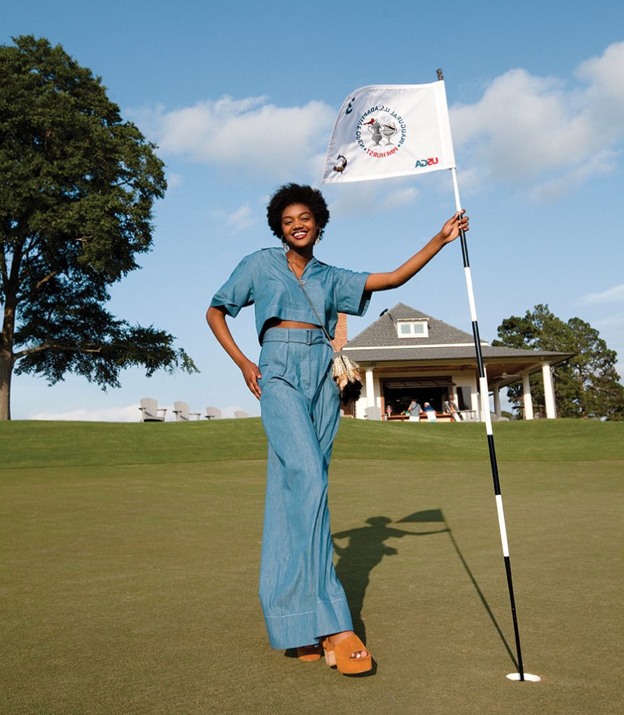 Model Carmen York at The Cradle golf course holding a flagstick.