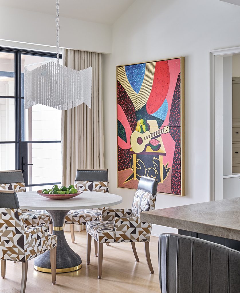 Left: An abstract painting by Brian Rutenberg adds a dash of bold color in the foyer. Right: A painting by Russ Warren creates a striking backdrop in the breakfast nook. The table and drum light fixture are from Made Goods; the chairs are Vanguard.