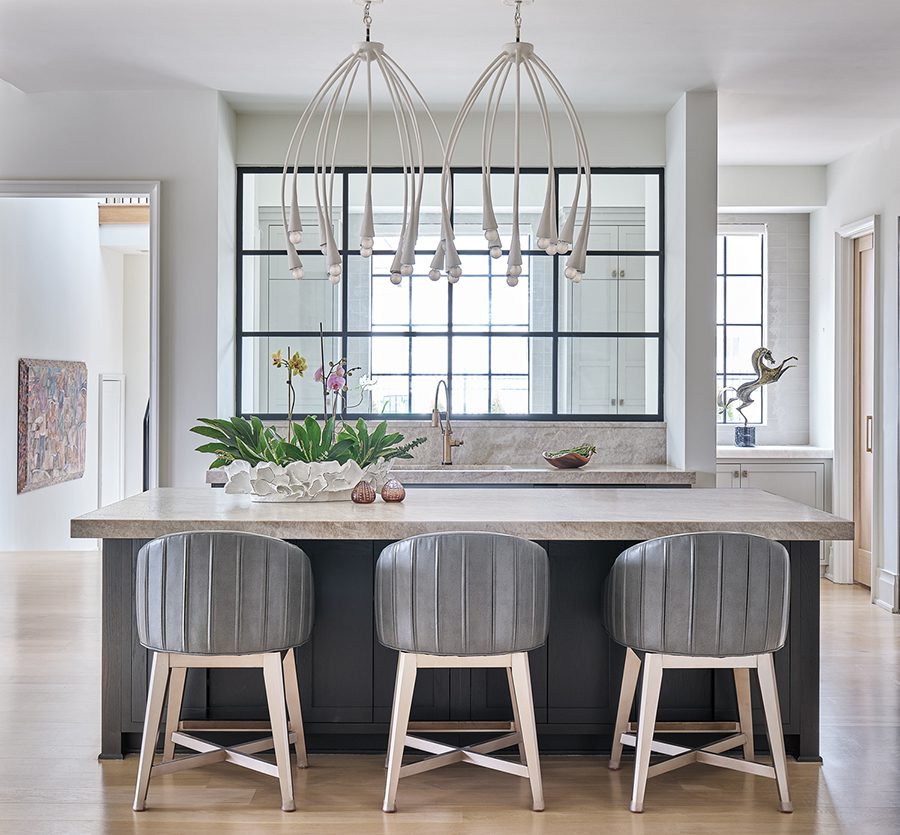 Pendants by Julie Neill hang over the kitchen island; the counter stools are by Vanguard.