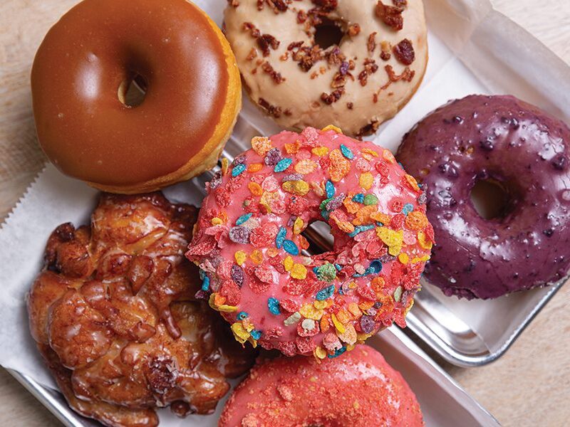 Stacks of colorful doughnuts inside OMG Donuts & Coffee in Charlotte's MoRa neighborhood.