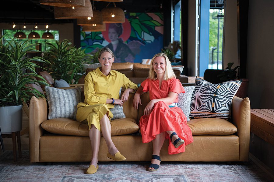 Rally founders Meg Charity and Barrett Worthington sit on a couch at the new pickleball and entertainment venue in Charlotte.