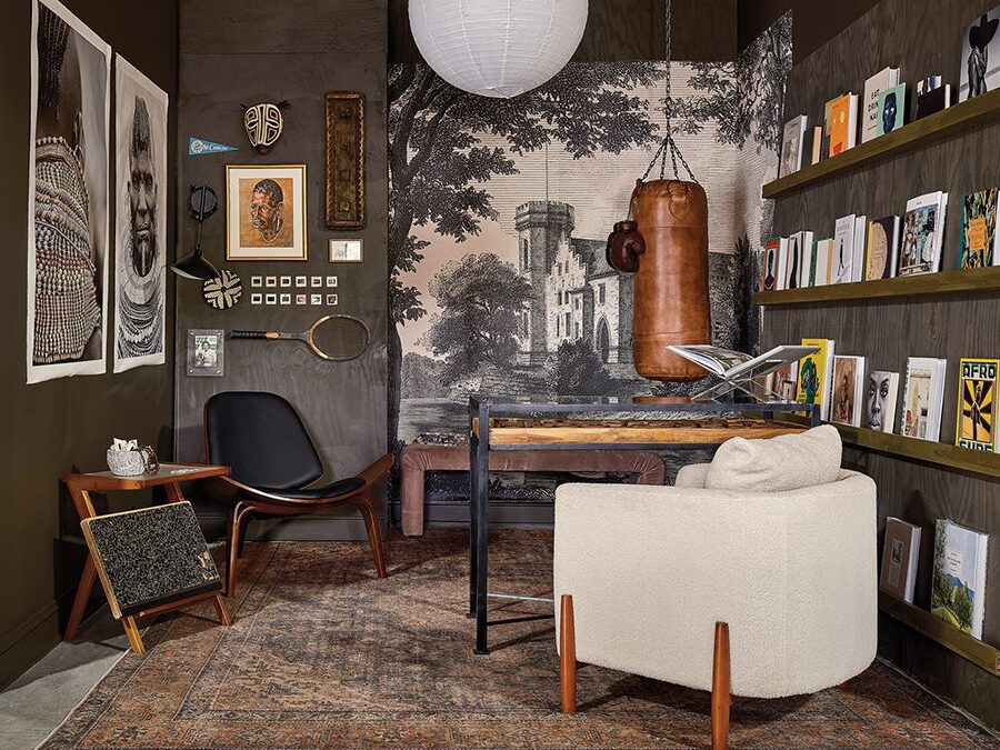 Ashley Ross of Muse Noire Interiors designed this moody sitting area with books lining the wall for Furnished, a design competition in Charlotte.