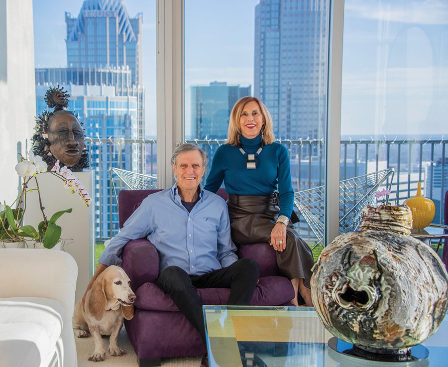 Lorne Lassiter and Gary Ferraro sitting on the couch of their condo in uptown Charlotte with their dog, Kobe.