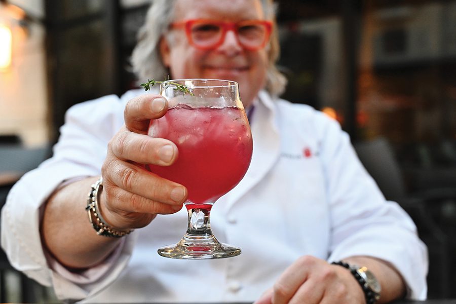 Chef David Burke holds a cocktail at his restaurant in SouthPark, Fox & Falcon.