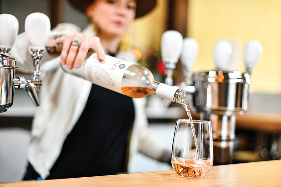 A woman pours a drink inside Free Range Bar in Camp North End.