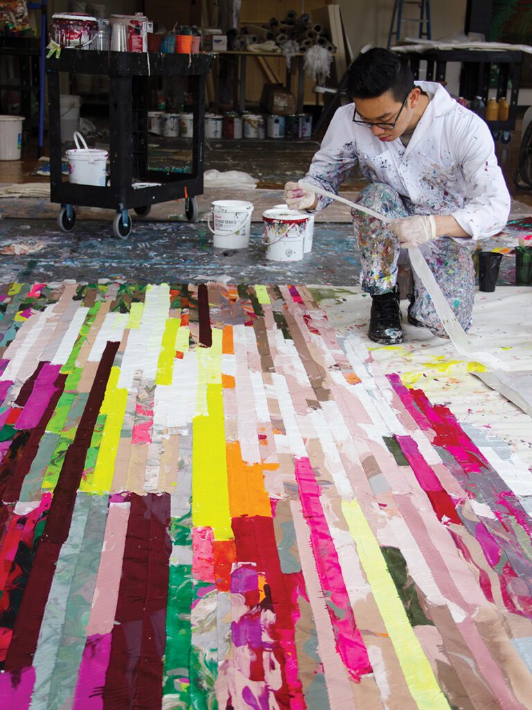 Artist Kenny Nguyen working in his studio on a hand-cut silk piece.