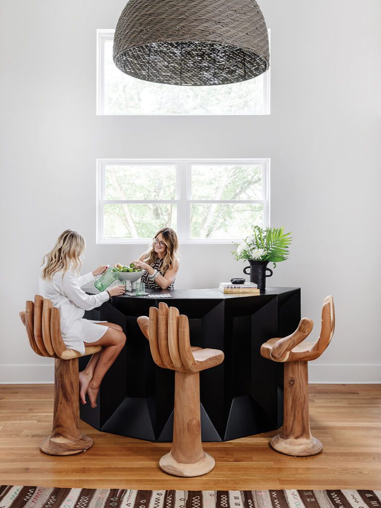 House of Nomad designed Oakhurst home: angular black metal bar with teak barstools