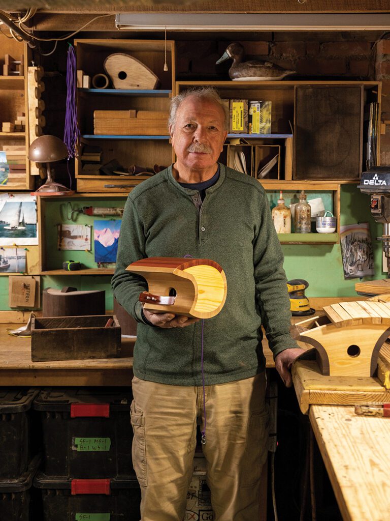 Mark Ellis, owner and craftsman of Koolbird House, holds a birdhouse inside his workshop in the Dilworth neighborhood of Charlotte.