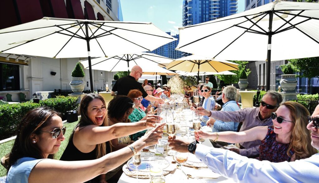 Friends toasting and dining al fresco in uptown during Charlotte Food + Wine Week.