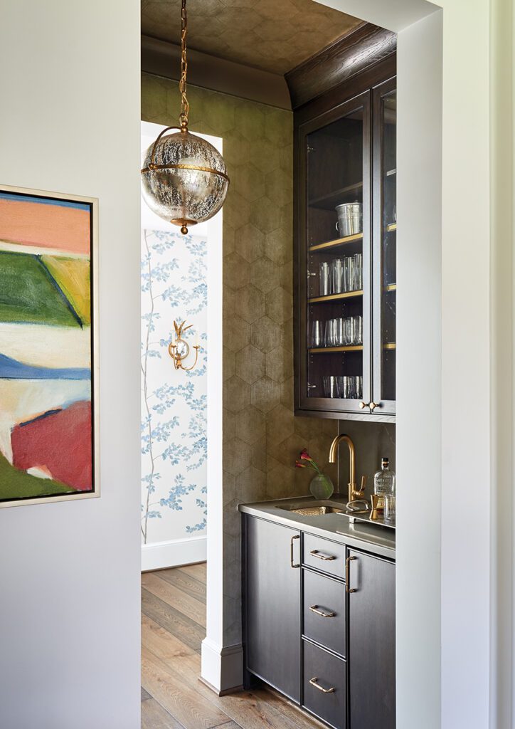 A Cole & Son wallpaper with a geometric design adds a subtle sheen in the bar area of this home in Charlotte's Foxcroft neighborhood.