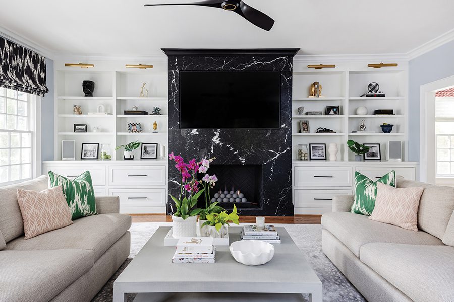 Black-and-white leathered marble surrounds the family-room fireplace of this home in Myers Park in Charlotte. Window treatments are a modern black ikat fabric by Thibaut.