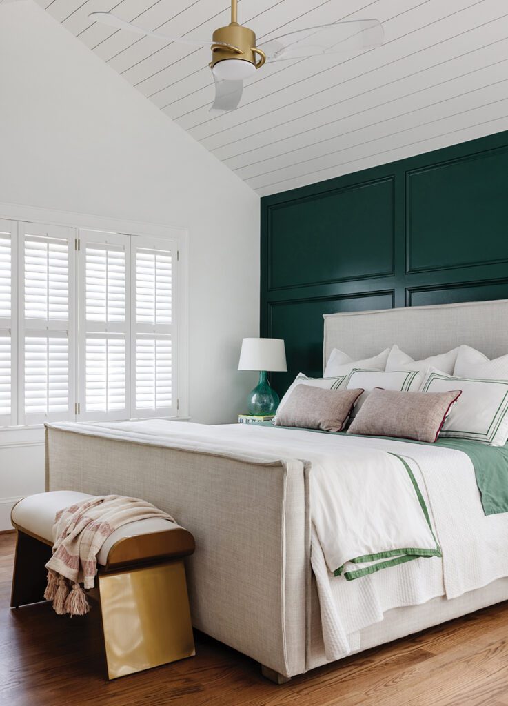 A vaulted ceiling in the primary bedroom creates a brighter, airier space. The homeowner’s favorite color, emerald green, accents the room.