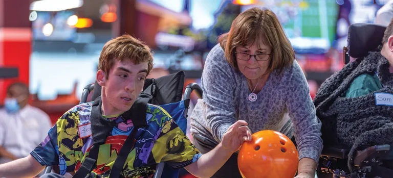 Volunteer Linda Riedel assists Ben, the author’s son, at a group outing at Bowlero in Matthews