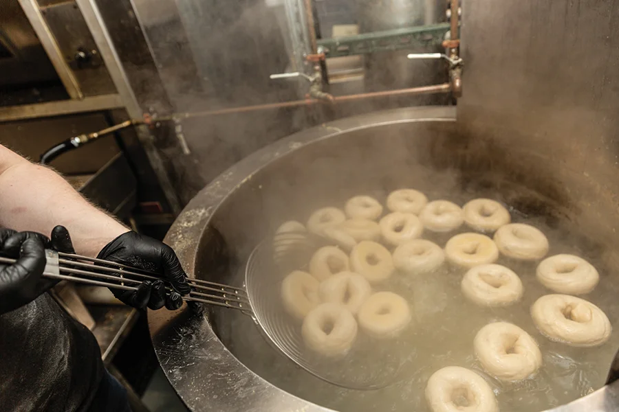 Boiling bagels in a large vat