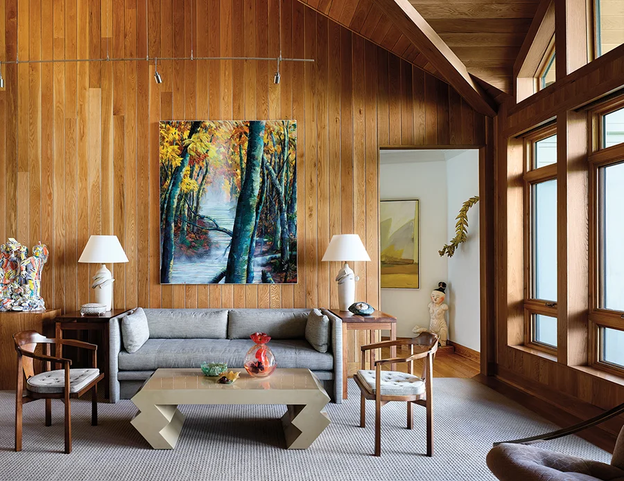 The painting over the sofa, “October Calling,” is by Yanceyville native Maud Gatewood. The sculpture, far left, is by ceramic artist Viola Frey. In the hallway to the right, a glimpse of a painting by Lee Hall and a serpentine-like sculpture by ceramicist Michael Sherrill.