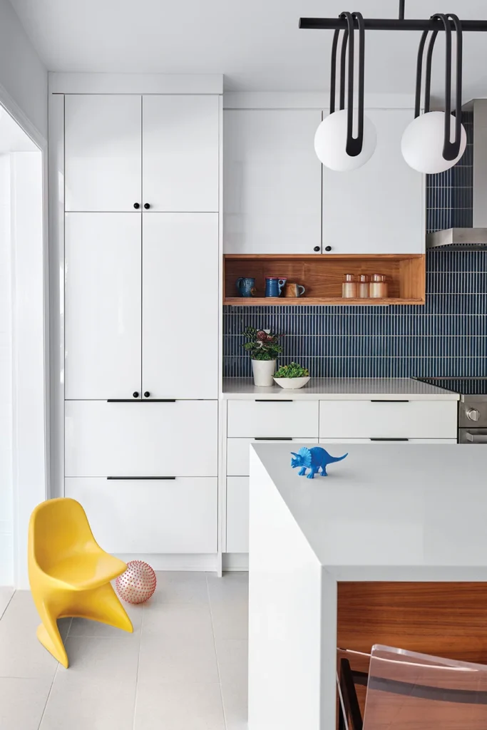 Midcentury Barclay Downs split-level kitchen redesign by Erin Hodges and Dominion Remodeling. White cabinets with kids toys.