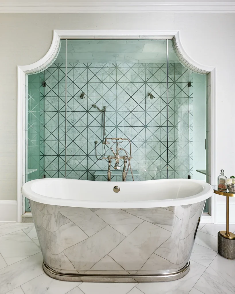 In the primary bathroom, the centerpiece is a polished-nickel bathtub, which is complemented by a polished-nickel pattern in the Walker Zanger shower tile.