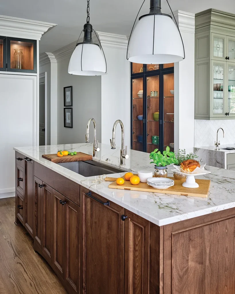 Visual Comfort pendants illuminate the island, anchored by a two-faucet Galley sink from Bird Decorative Hardware.