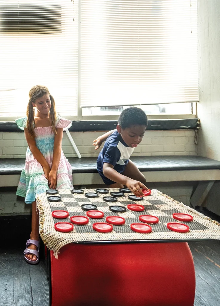 Eva watches boy play checkers