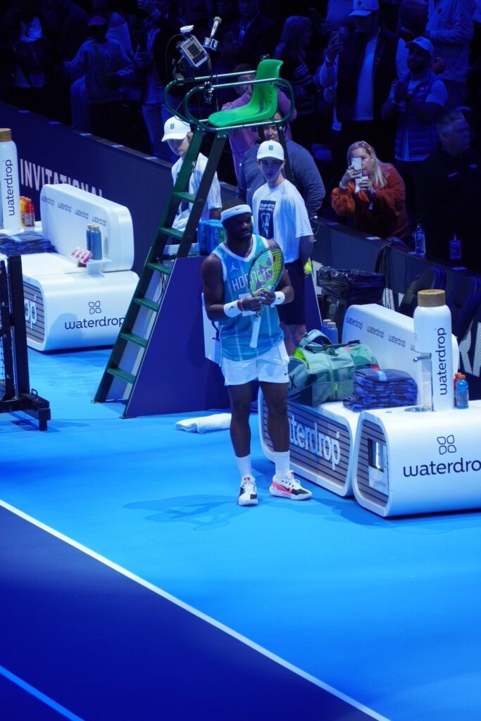 Frances Tiafoe holds his tennis racquet while wearing a Hornets jersey during the Charlotte Invitational. Photo by Ashley Stroehlein.