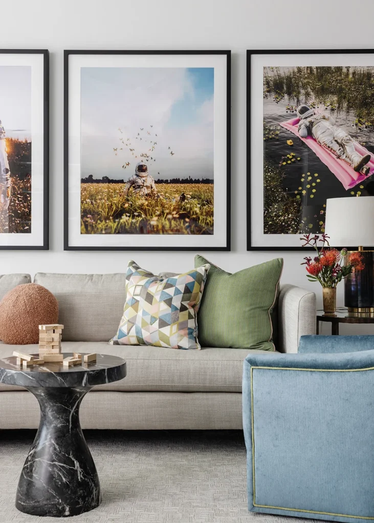 Three playful astronaut photographs — one for each daughter — hang above the sofa in the playroom. The geometric pillow fabric is by Imogen Heath.