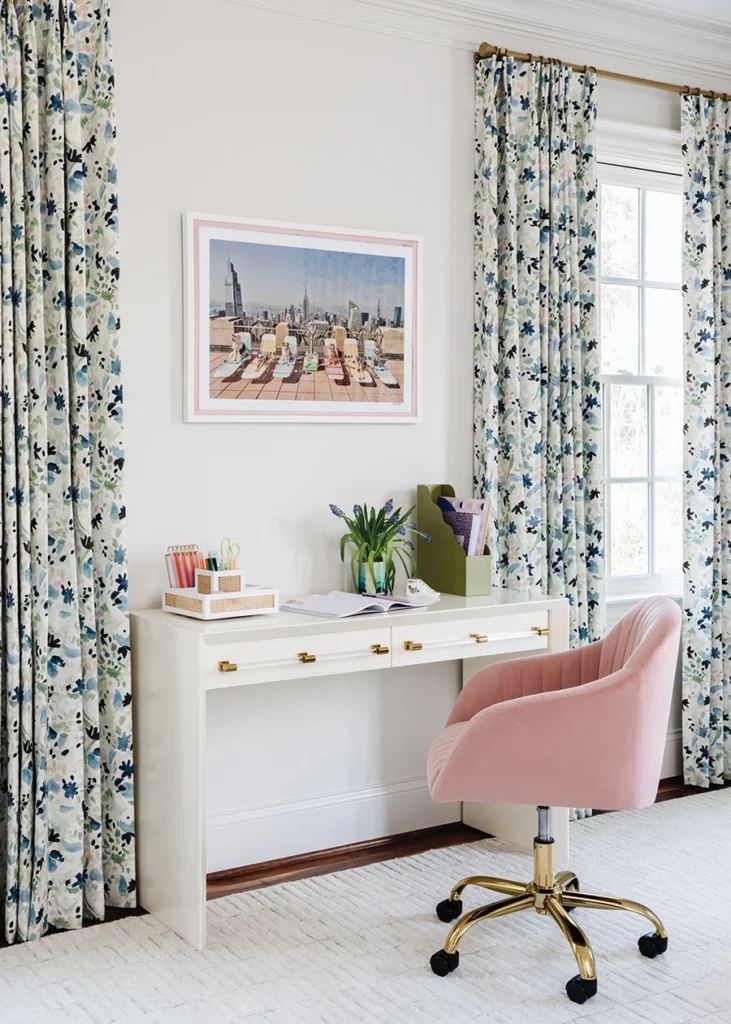 A floral fabric by Rebecca Atwood frames the windows in a daughter’s room. All Modern’s pink velvet chair is paired with an Anthropologie desk