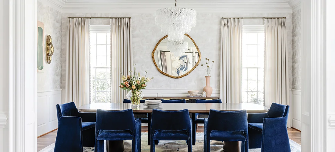 A Soho Home chandelier illuminates the dining room, where blue velvet CB2 chairs surround the table.