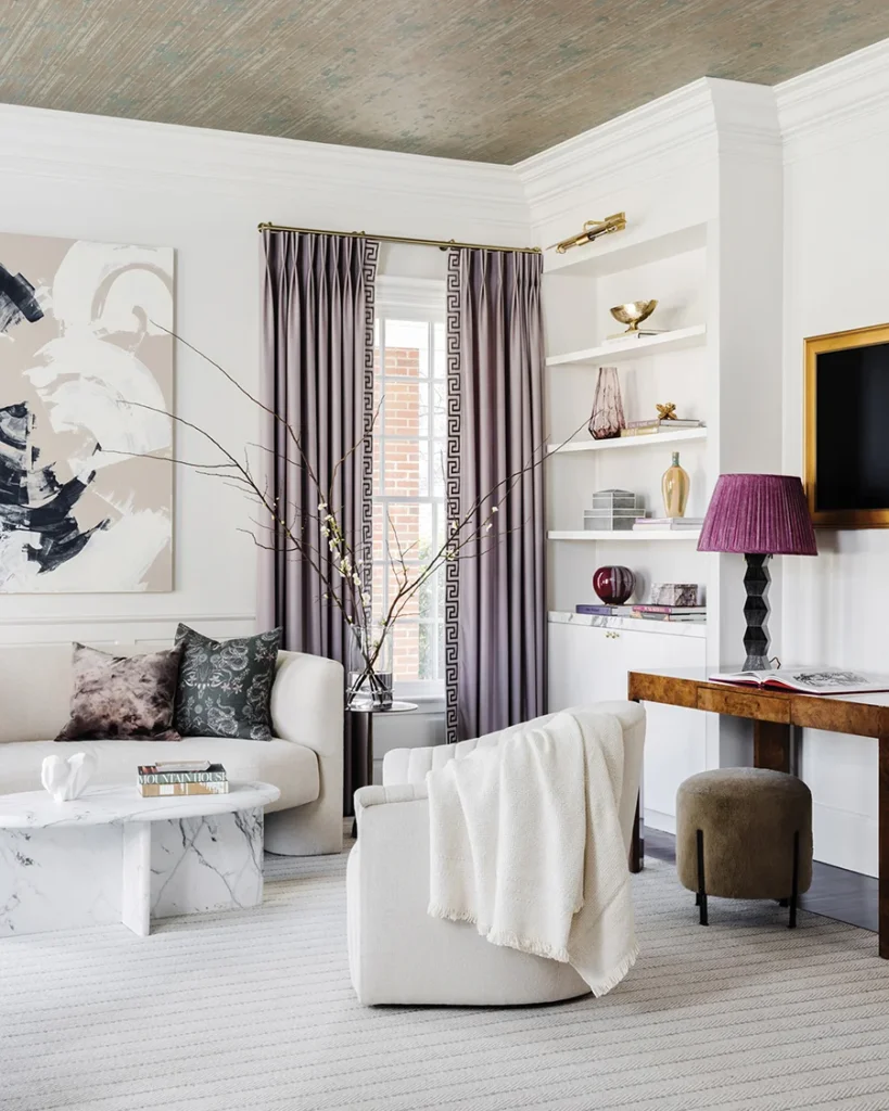 The living room color palette is subdued with pops of color, including the lavender drapery fabric by Holland & Sherry.