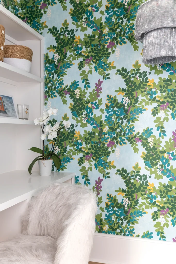 A closet workspace is brightened with wallpaper by Thibaut.The desk chair is from RH Home.
