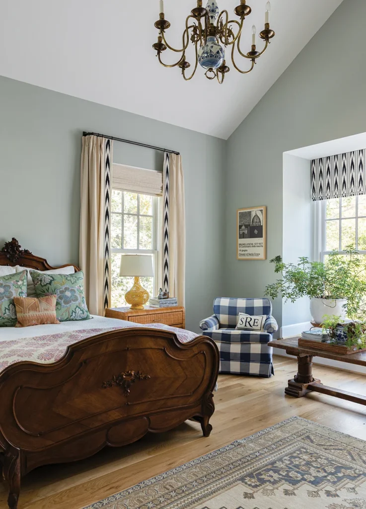 The antique French bed in the primary bedroom is a hand-me-down from Stephanie’s parents. She bought the drapery trim at a women’s co-op near Lake Atitlan, Guatemala. She found the Delft chandelier from a seller in Spartanburg, South Carolina, via Facebook Marketplace. Stephanie purchased one of the bedside tables at an estate sale then tracked down a matching table on Etsy to complete the pair.