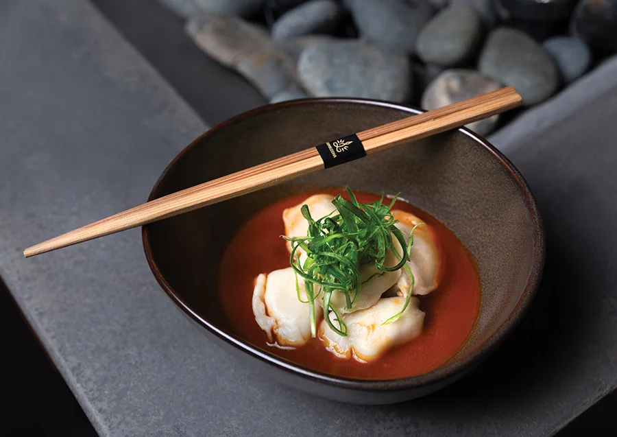 Steamed BBQ Chicken Dumplings with a spicy Asian dipping sauce and scallions