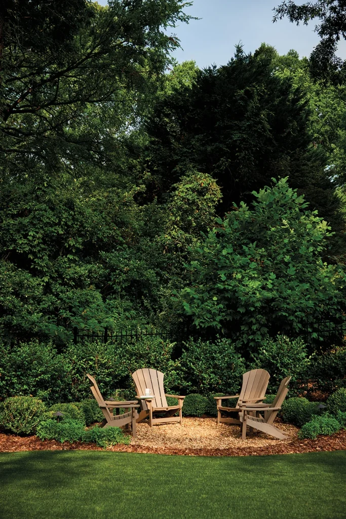 A group of Adirondack chairs creates a cozy spot for coffee or conversation, with space for a portable fire pit on chilly evenings designed by Erin Peiffer