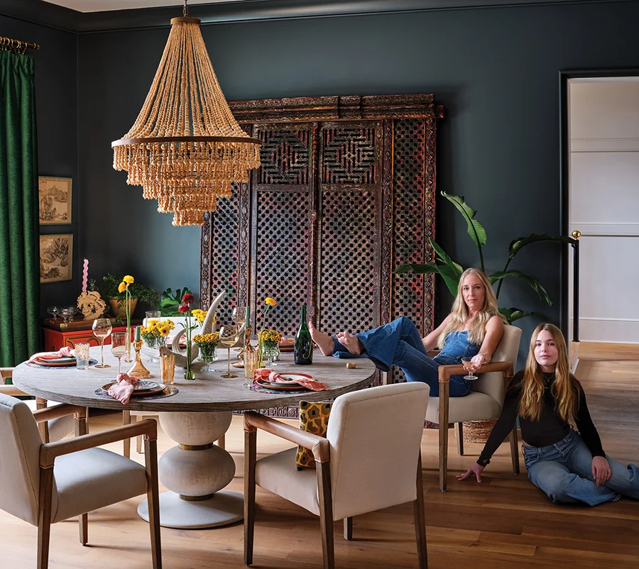 The not-too-formal dining room is open to the kitchen. Annie, shown here with her daughter Maeve, found the carved wooden doors at Gibson Mill in Concord