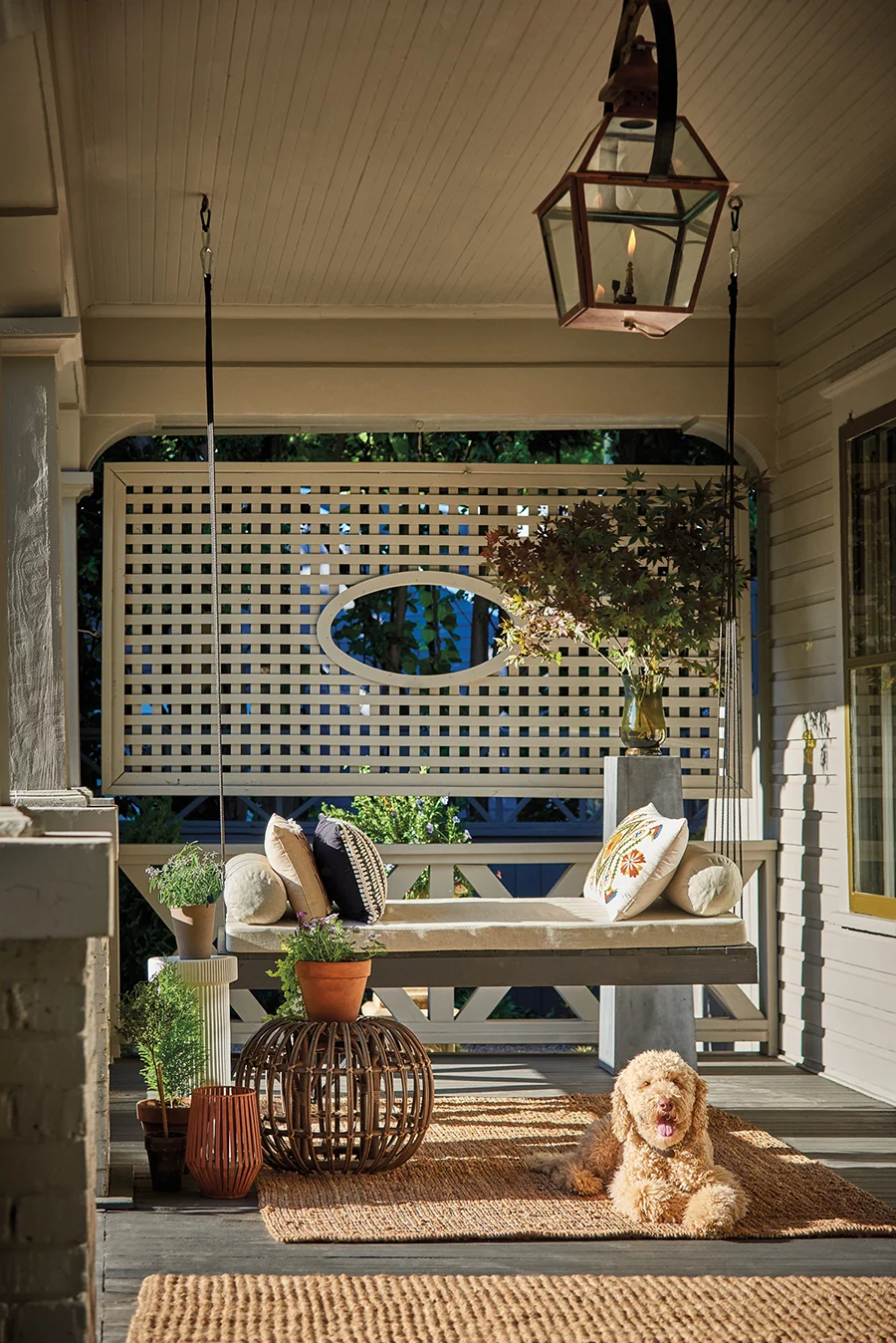 Ligon’s 9-year-old labradoodle, Teddy, happily rests on the front porch. Ligon designed the lattice structure behind the swing to offer an attractive backdrop and cozy gathering space.