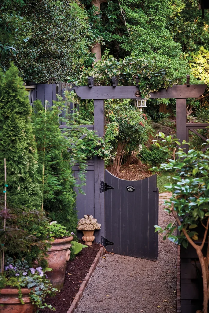 A jasmine vine grows atop a garden gate, which leads to the backyard.