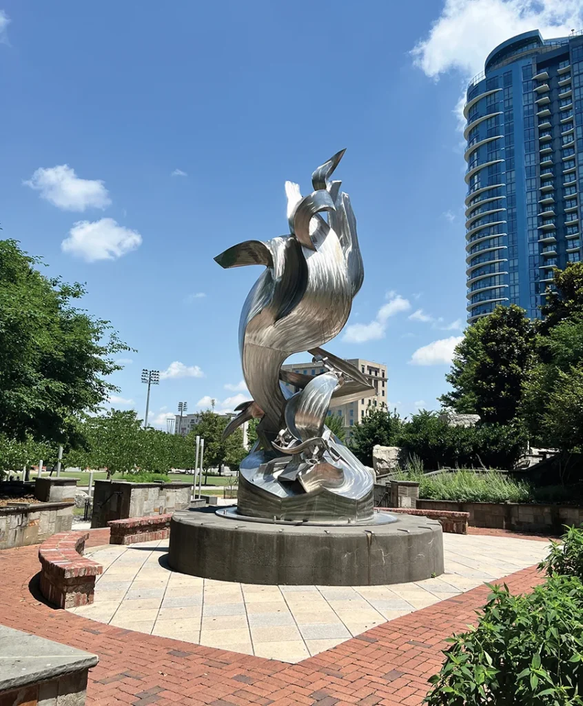 Spiral Odyssey sculpture gleams in the sun at Romare Bearden Park in uptown Charlotte.
