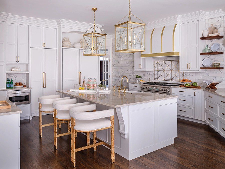The dark, ’90s-era kitchen was transformed into a light, bright space for cooking and entertaining. The brushed brass light fixtures are from Hudson Valley Lighting. A mixer stand with a pull-out shelf is built into the island.
