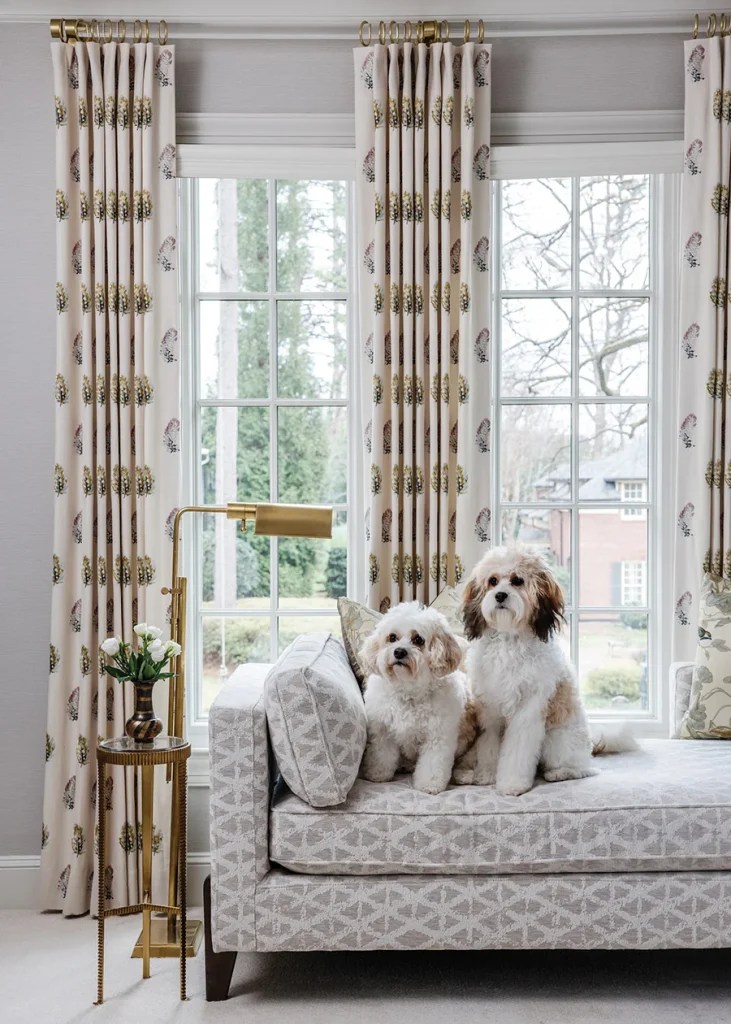 A slim daybed fits the narrow space in front of the window, dressed with draperies in a feather pattern.